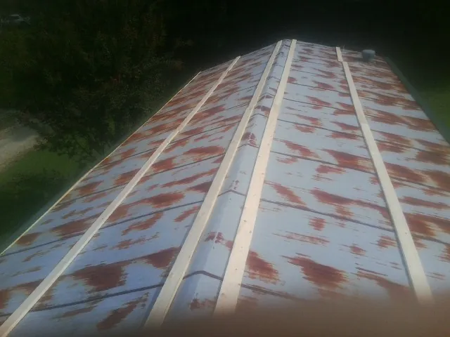 Rusted metal roof panels with new wood purlins before replacement — Storm Damage Roof Repair in Fort Calhoun by Roofing Brothers