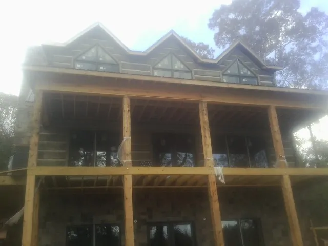 Dormers and porch framing on a large log home under construction — Roof Coating work by our crew in Fort Calhoun