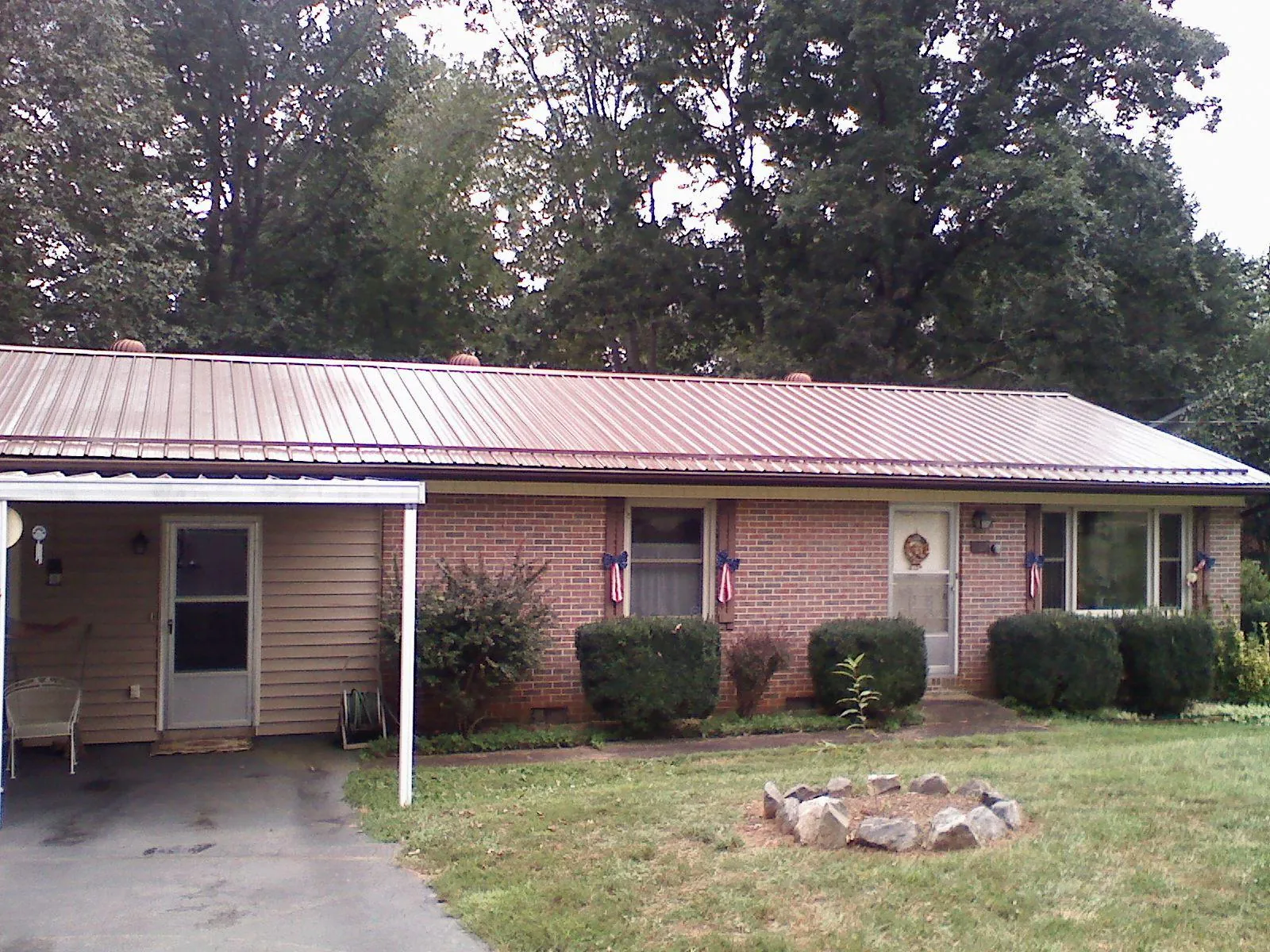 Bronze metal roof and carport on a brick ranch home — Roof Repair work by our crew in Fort Calhoun